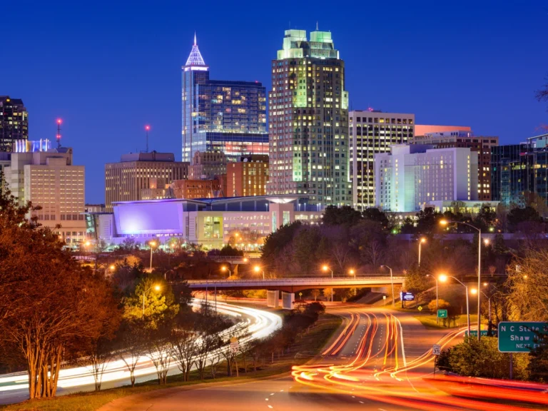 Modern Raleigh skyline at night, illustrating the transformation of North Carolina's capital from a small planned city into a thriving metropolitan center and economic hub.