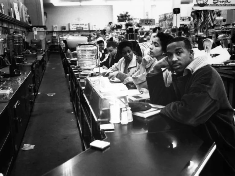 Civil rights-era sit-in protest by African American students, reflecting the social and economic challenges faced by Black communities in Raleigh during the urban renewal period of the 1960s and 1970s.
