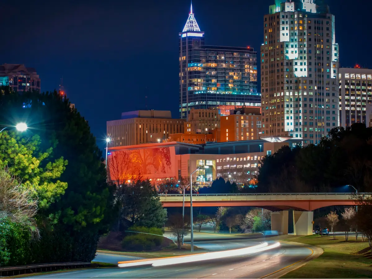 Modern downtown Raleigh at night, representing the city's growth from the historic Black business district along Hargett Street to today's thriving urban center.