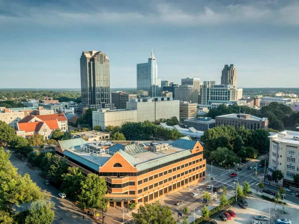 Panoramic aerial view of downtown Raleigh, NC, showcasing the city's skyline, business district, historic architecture, and urban development in North Carolina's capital city.