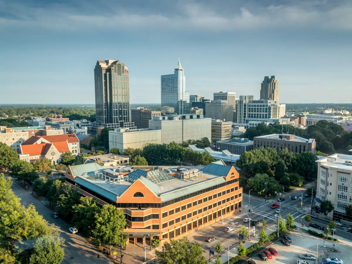 Panoramic aerial view of downtown Raleigh, NC, showcasing the city's skyline, business district, historic architecture, and urban development in North Carolina's capital city.